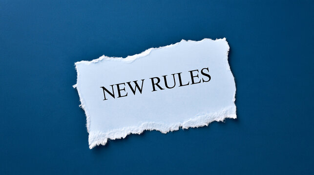 Torn white paper with the text new rules written on it against a blue background. Ideal concept for business policy changes and strategy updates.