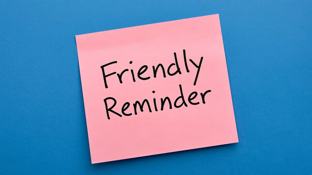 Pink sticky note with friendly reminder handwritten text on bright blue background. Perfect for office communication and time management concepts.