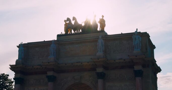 Sun rays shining through the quadriga on the Arc de Triomphe du Carrousel in Paris