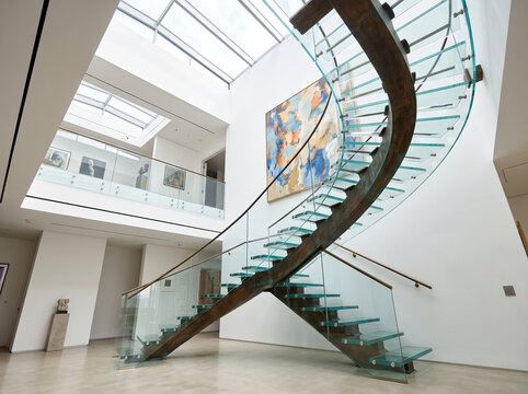 Modern luxury interior architecture with floating glass and wood spiral staircase