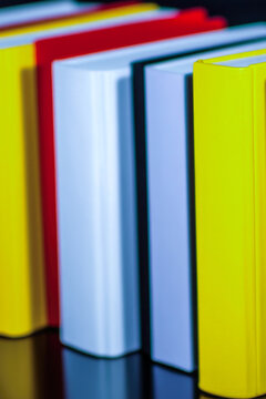 A stack of books resting on a table, ideal for use in educational or office settings. vertical frame