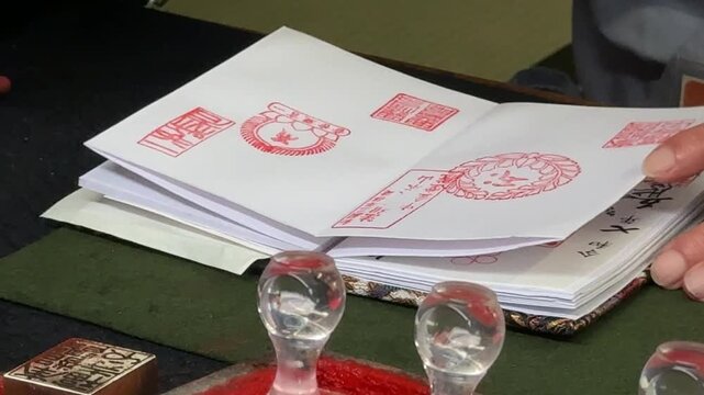 Collection of traditional Japanese red ink stamp impressions inside a goshuincho stamp book