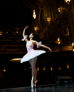 Ballerina performing on pointe in an ornate theater