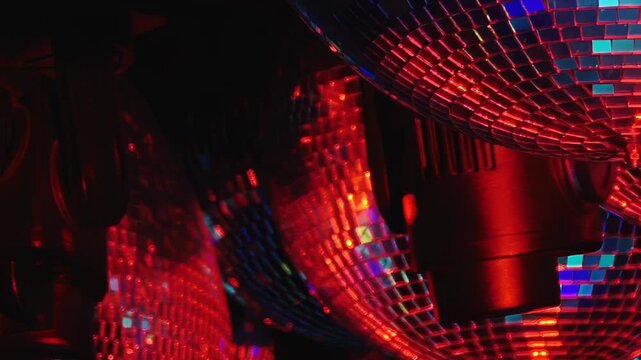 Red disco ball tiles catch fragmented blue and green reflections. A close mirrored surface glows mainly red with fragmented green and blue reflections forming geometric light texture.