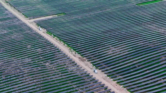 White inverter stations serve blue photovoltaic arrays across Tume, Latvia