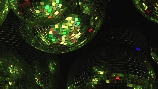 Mirror ball close ups show red green blue and silver reflections. Close views of individual mirrored spheres alternate between red, green, blue, purple and bright silver reflections.