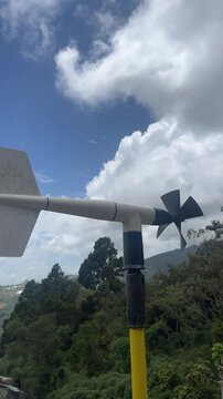 Wind vane and anemometer measuring wind on cloudy hilltop