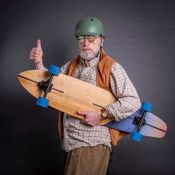 casual portrait of a bearded senior man with a long cruising skateboard