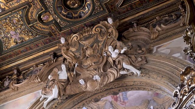 Baroque stucco angels and gilded scrollwork crown an ornate arch inside San Gregorio church in Naples.