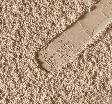Makeup foundation face powder swatch on textured powder background