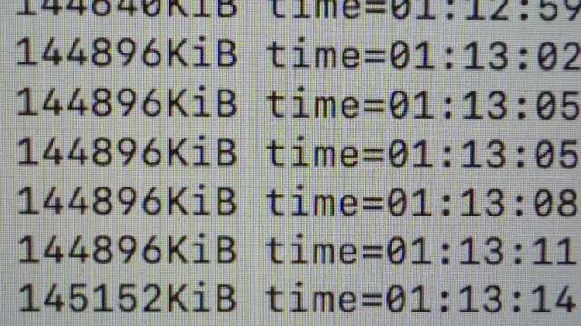 Extreme close-up of real time video encoding data with file size and elapsed time values continuously updating on a computer display, representing media processing, compression and digital workflows.