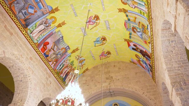 Interior View of Vibrant Colorful Ceiling Paintings at St George's Greek Orthodox Church in Madaba, Jordan. Detailed Byzantine Style Frescos and Religious Iconography.