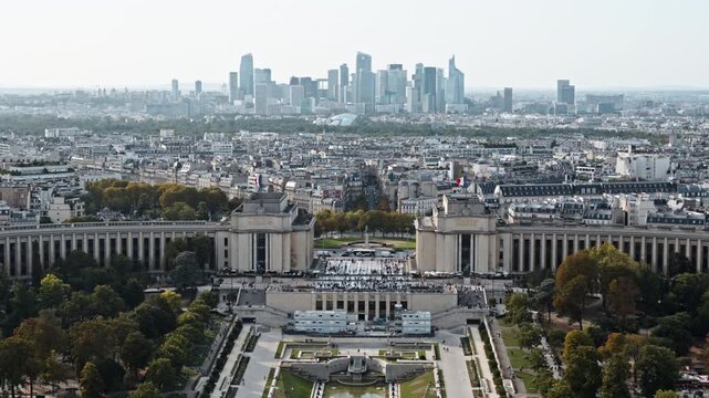 Crowds fill the Palais de Chaillot terraces and gardens while La D&eacute;fense business district rises on the distant horizon.