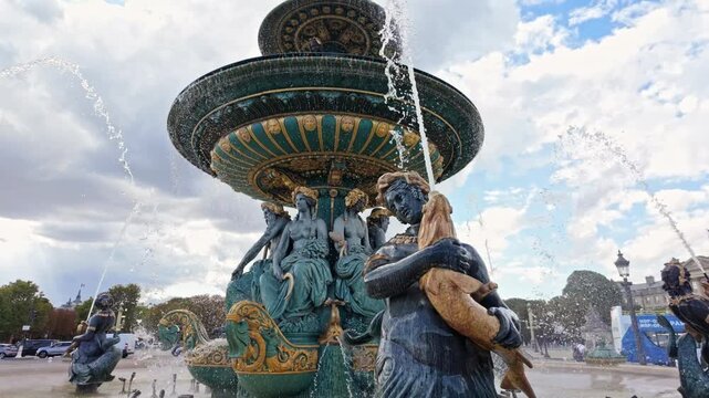 Fontaine des Mers statues and spouting water fill the frame at Place de la Concorde on a cloudy day.