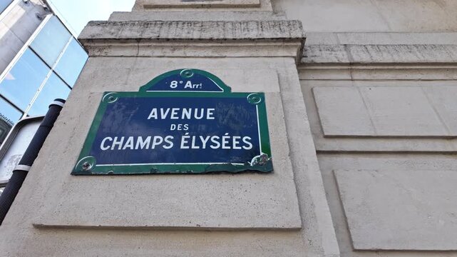 Street plaque for Avenue des Champs-&Eacute;lys&eacute;es in the 8th arrondissement fills the frame against a stone building facade.