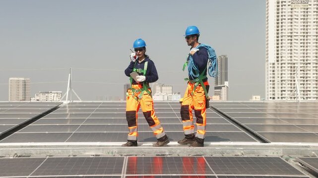 Two solar technicians inspecting rooftop photovoltaic panels, one adjusting panel alignment while colleague points and checks installation details.