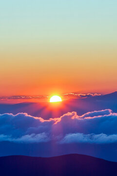 A serene sunset scene with clouds in the background, ideal for use in travel or nature-related projects. vertical frame