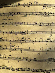 Fototapeta premium Close up of aged sheet music with musical notes and textured paper. Music notes Sheet on Aged Paper, black notes on brown paper, musical score, sheet music, musical notation, classical music 
