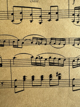 Close up of aged sheet music with musical notes and textured paper. Music notes Sheet on Aged Paper, black notes on brown paper, musical score, sheet music, musical notation, classical music 