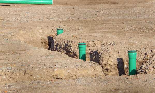 Multiple plastic drainage pipelines aligned in the ground during excavation works, highlighting sustainable sanitation management systems, infrastructure maintenance, and public works upgrade projects