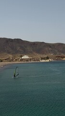 High angle view of a windsurfer gliding on turquoise sea water in Cabo de Gata Spain  © Irina