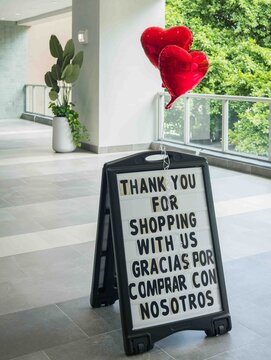 Thank You for Shopping Sign with Red Heart Balloons in Modern Shopping Center