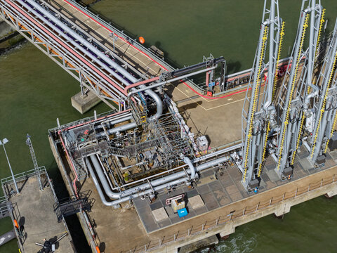 Industrial Loading Arm Structure and Pipelines Extending Over the Water at a Harbor Facility