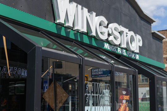 exterior building facade and sign of Wingstop, a chicken wings restaurant chain, located here at 780 Danforth Av, Toronto