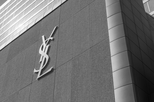 black and white view of exterior building facade and sign of Saint Laurent, a high end designer clothing store, located here at 110 Bloor St W, Toronto