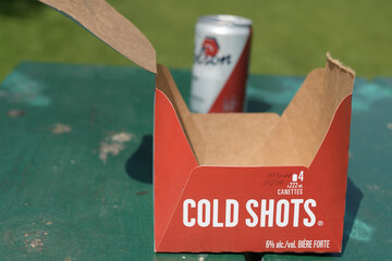 Obraz premium isolated Molson Cold Shots Lager cardboard carrier and defocused beer can on a picnic table in Toronto