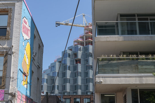 donut shop and apartment balcony with exterior of KING Toronto Condos designed by Bjarke Ingels Group (BIG) in the area of King W and Portland