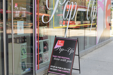 Obraz premium sidewalk a-frame poster sign and exterior of TIFF Lightbox, a movie theatre, located at 350 King St W, Floor 1 of the Festival Tower, Toronto