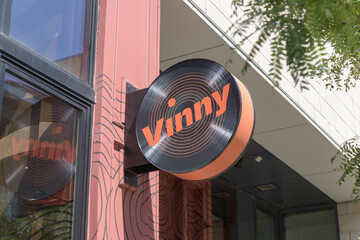 Fototapeta premium wall-mounted projecting circle sign of Vinny Toronto - Restaurant & Vinyl Bar, located at 480 King St W