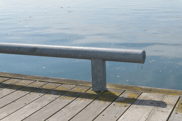 low-profile pedestrian barrier on wood promenade by the lake © eugen