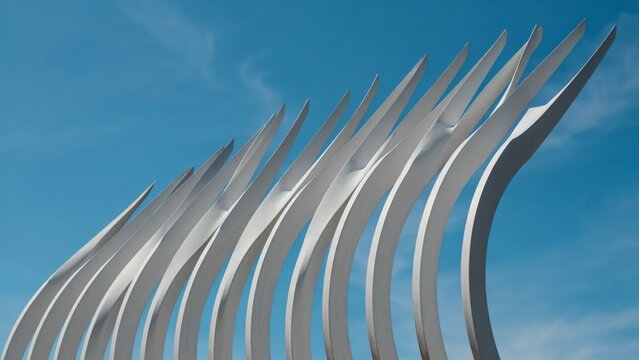 Abstract white architectural pattern of curved blades fanning upward against a clear blue sky