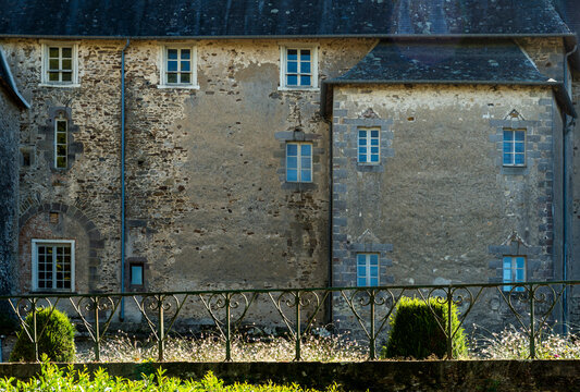 France, Lot, Chateau Pompadour.  Architectural detail of the stone wall and windows at the back of the chateau.