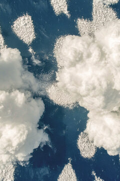 A pair of clouds floating in the sky, no storm or rain. vertical frame
