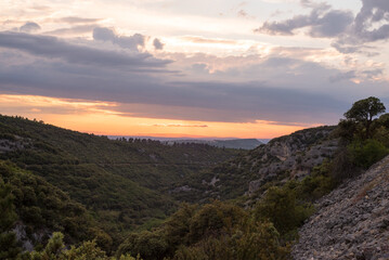 Fototapeta premium Abendstimmung mit lebhaftem Wolkenhimmel über weitläufiger Landschaft der Provence Frankreich 