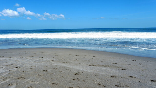 Scenic tropical beach with gentle ocean waves, sandy shoreline, and clear blue sky