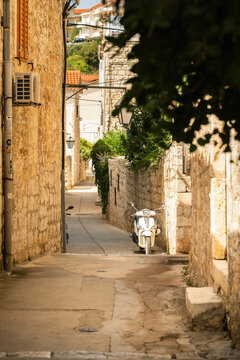 Narrow stone alley with a scooter in Hvar old town Croatia
