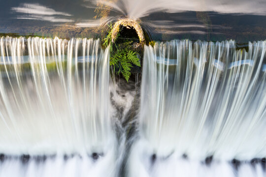 France, Lot, Beaulieu Sur Dordogne.  Water streaming over small dam on the Dordogne River.