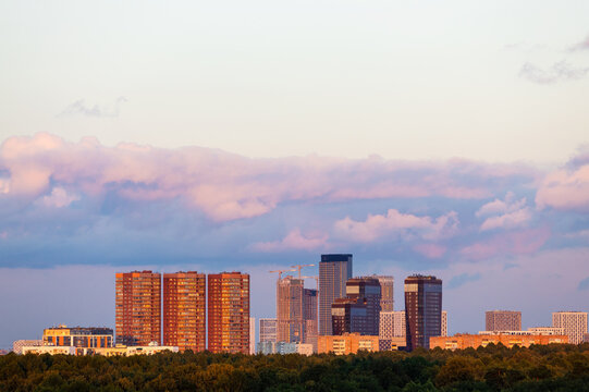 pink cloud in blue sunset sky over high-rise house