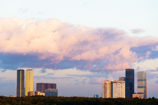 pink cloud in blue sunset sky over modern houses