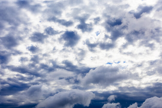 dark gray rain clouds close sun in dark blue sky