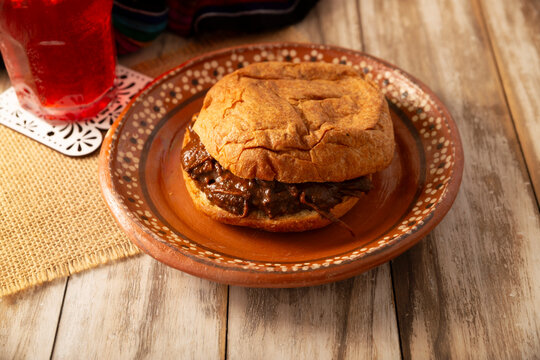 Authentic Mexican mole pastry sandwich on a rustic background. Tasty food photography with copy space. Mexican homemade food.