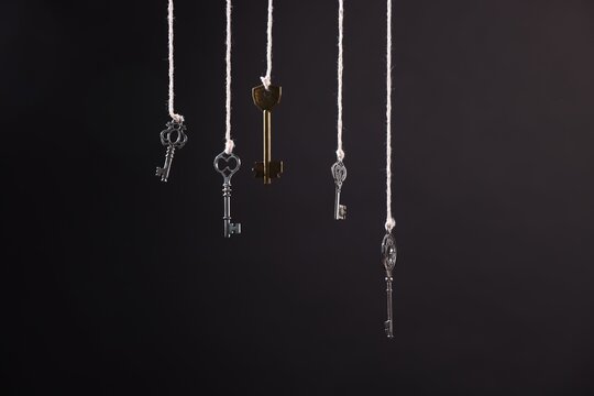 Choice concept. Different keys hanging against black background