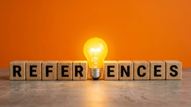 Wooden blocks spelling REFERENCES with a glowing yellow light bulb on an orange background.