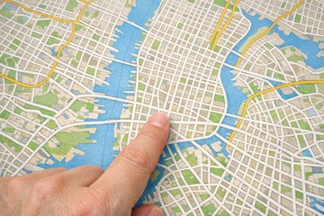 Obraz premium A person pointing on a map of a city, ideal for use in travel or real estate projects