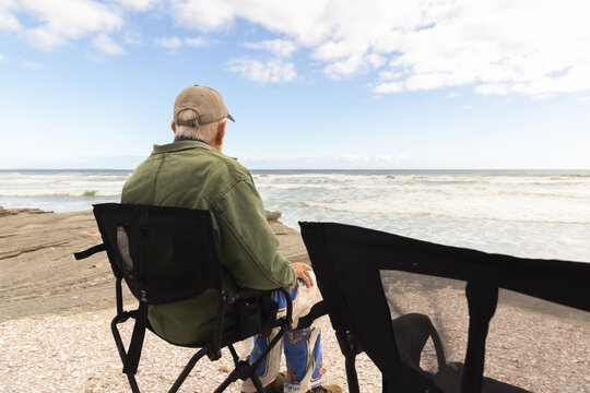 elderly man wearing baseball cap looking at Atlantis Ocean, South Africa