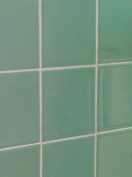 teal blue green square tile wall with white grout 